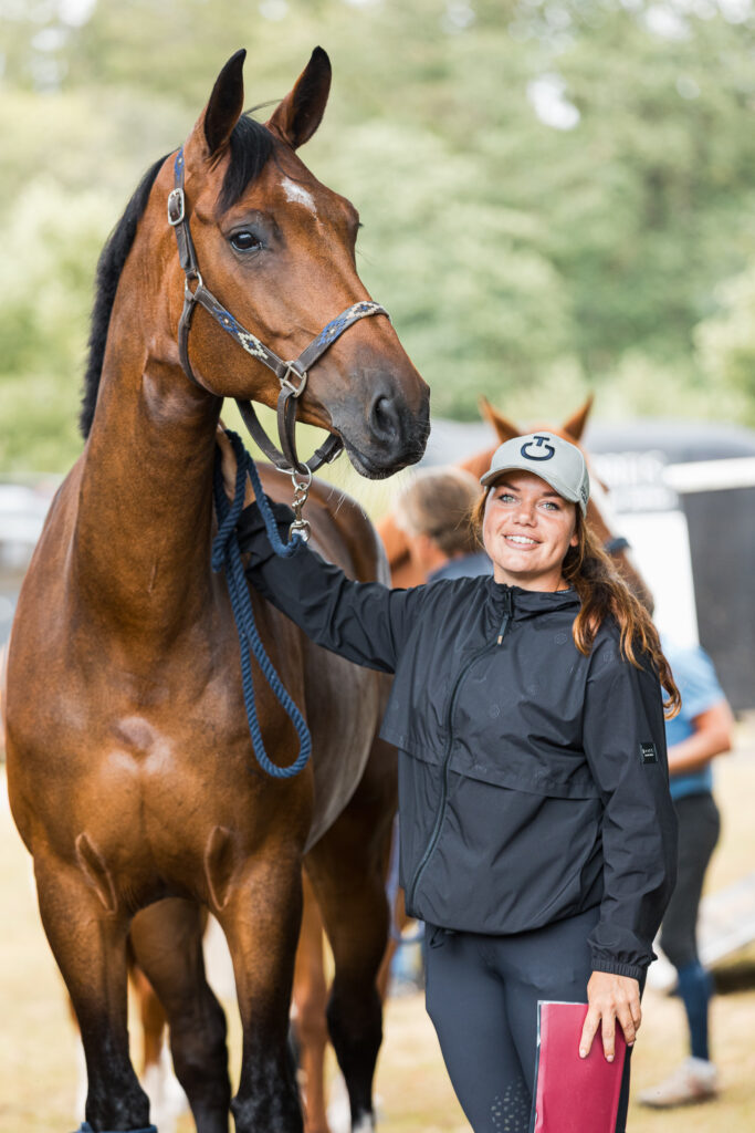 Lachende amazone houdt haar paard vast tijdens een vet check